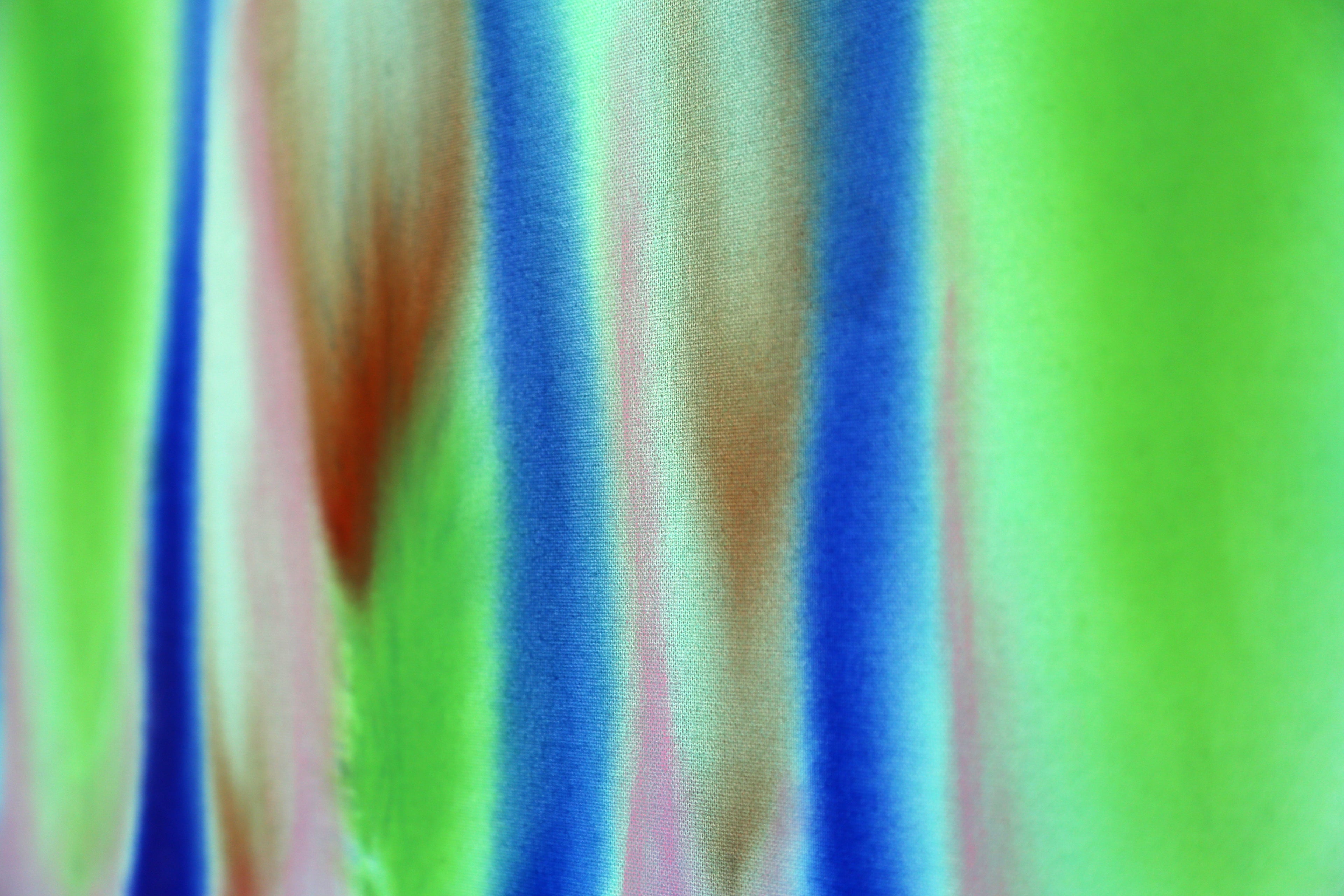 Colorful striped fabric with green, blue, and pink hues.