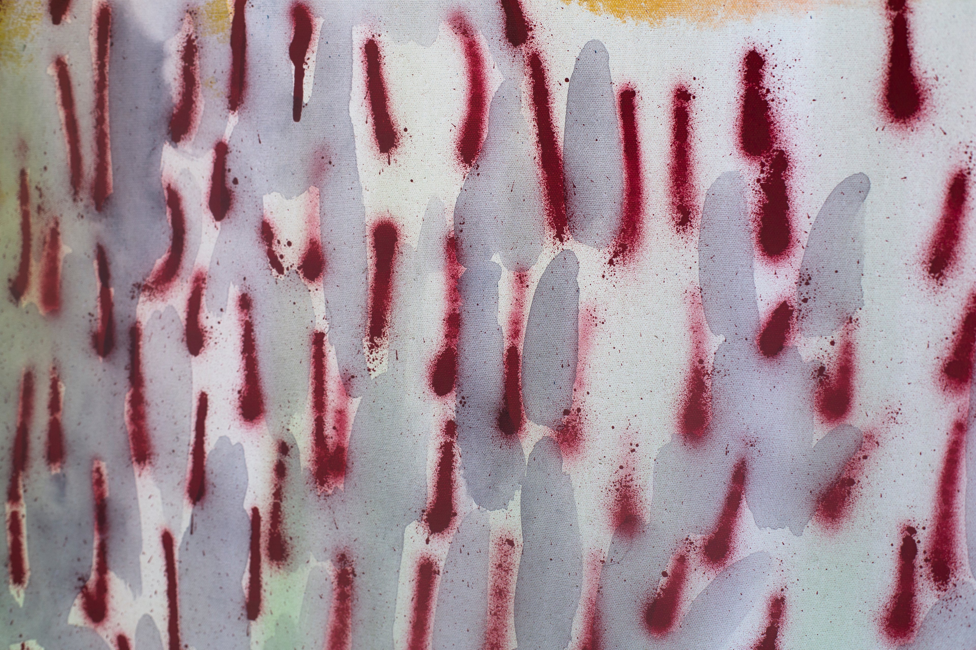 Detail of an abstract painting by Evgenia Makarova. Repeated crimson sprayed marks over pale grey and ochre on canvas.
