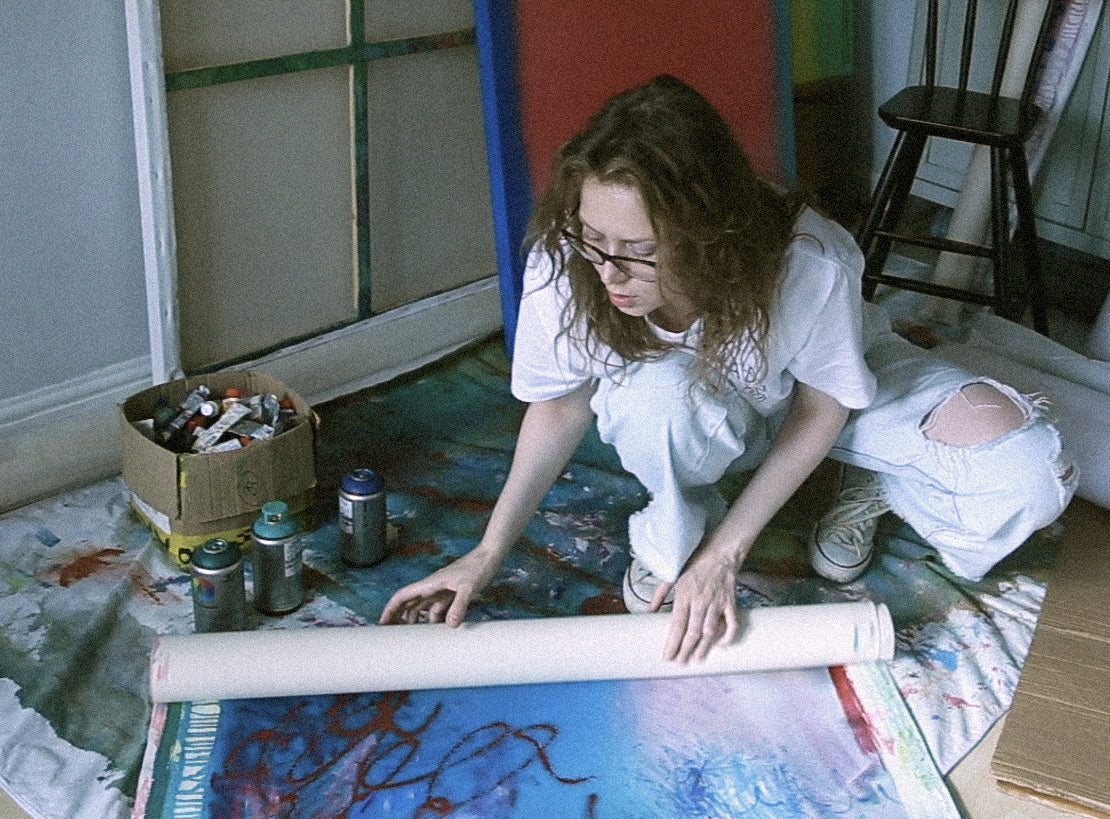 Evgenia Makarova in her studio in Aylesbury, unrolling a large work on canvas. Contemporary abstract artist.